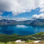 paket wisata danau toba: Pemandangan indah Danau Toba dengan air biru jernih dikelilingi pegunungan hijau, cocok untuk destinasi liburan hemat dengan paket wisata sesuai budget
