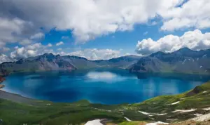 paket wisata danau toba: Pemandangan indah Danau Toba dengan air biru jernih dikelilingi pegunungan hijau, cocok untuk destinasi liburan hemat dengan paket wisata sesuai budget